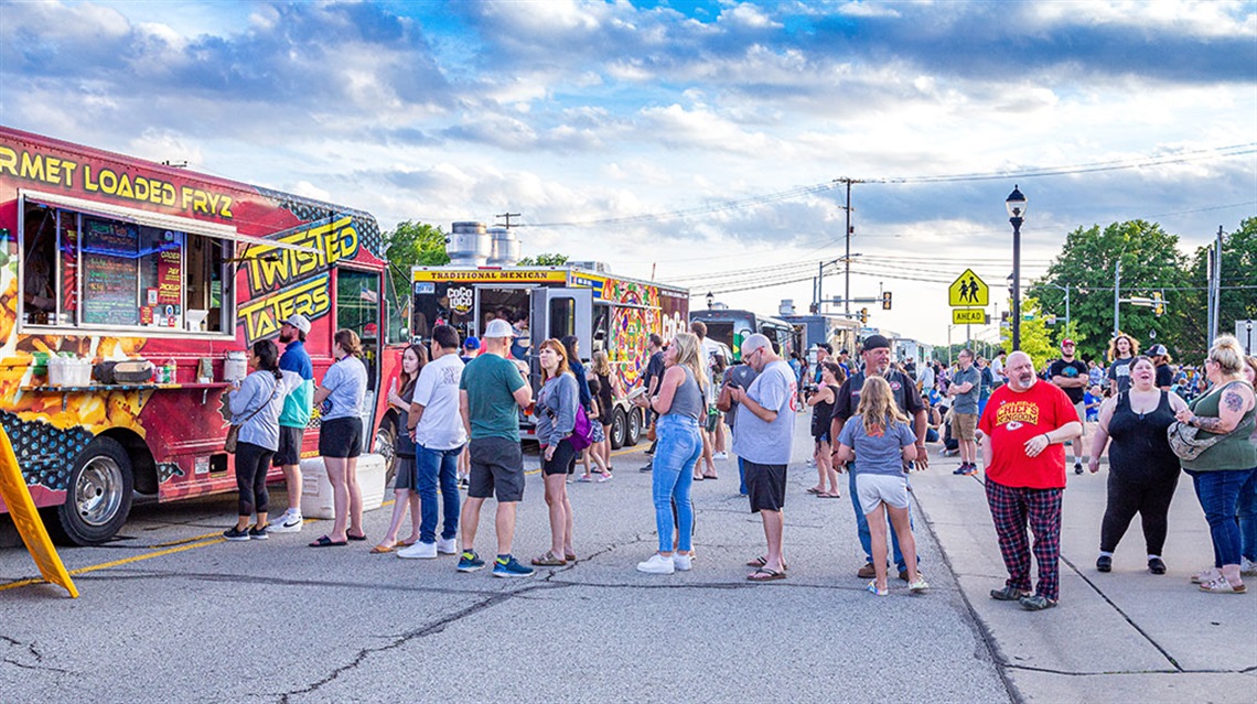 people waiting in line at food trucks