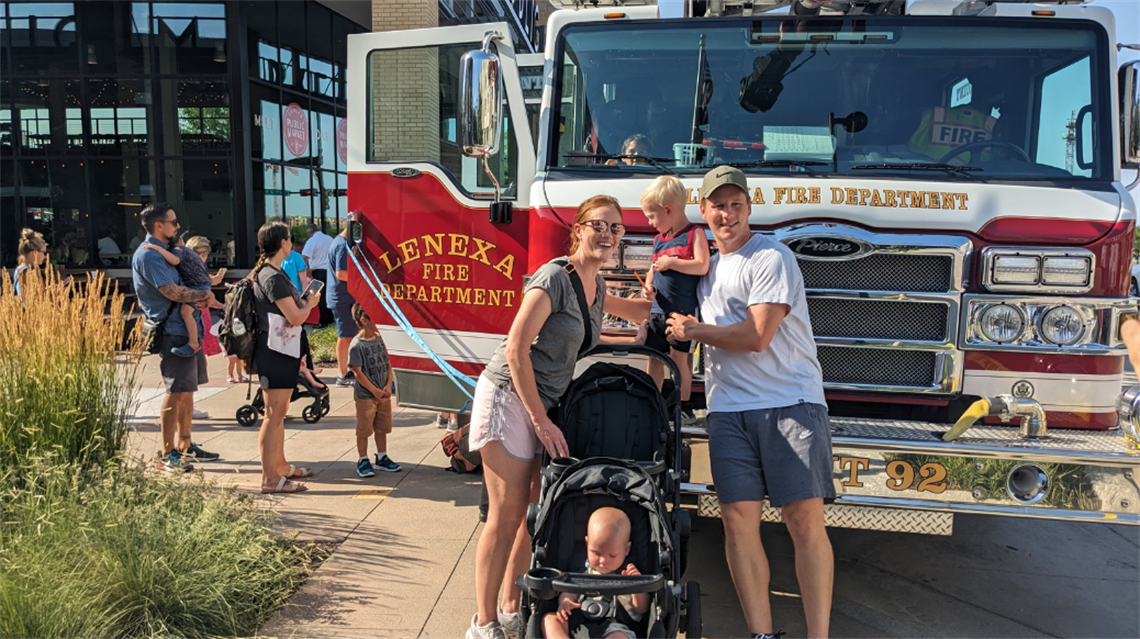 Family of four posing in front of fire truck outside the Lenexa Public Market.