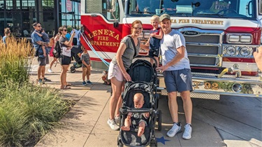 Family posing in front of fire truck for special guest appearance by the Lenexa Fire Department